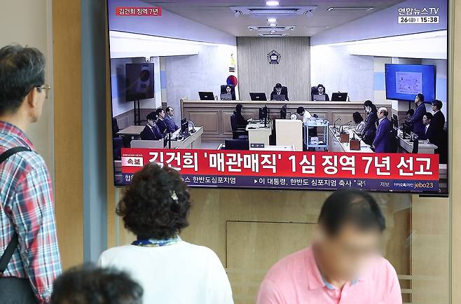 각종 고가 귀금속과 함께 인사·이권 청탁을 받은 이른바 ‘매관매직’ 혐의로 기소된 김건희 여사의 1심 선고 공판이 열린 26일 서울역에서 시민들이 공판 TV 생중계를 지켜보고 있다. 서울중앙지법 형사합의21부(조순표 부장판사)는 김 여사에게 징역 7년을 선고했다. 연합뉴스