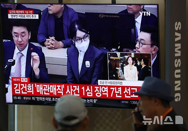 [서울=뉴시스] 조성우 기자 = 26일 서울 중구 서울역 대합실에서 시민들이 특정범죄 가중처벌법상 알선수재 혐의로 기소된 김건희 여사에 대한 1심 선고 공판 생중계를 보고 있다. 2026.06.26. xconfind@newsis.com