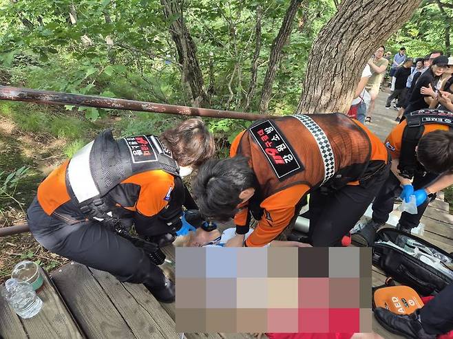[속초=뉴시스] 27일 폴란드 국적 60대 여성이 설악산에서 심정지 증상을 보이며 갑자기 쓰러져 구급대원이 긴급 조치에 나서고 있다.(사진=설악산사무소 제공)photo@newsis.com  *재판매 및 DB 금지