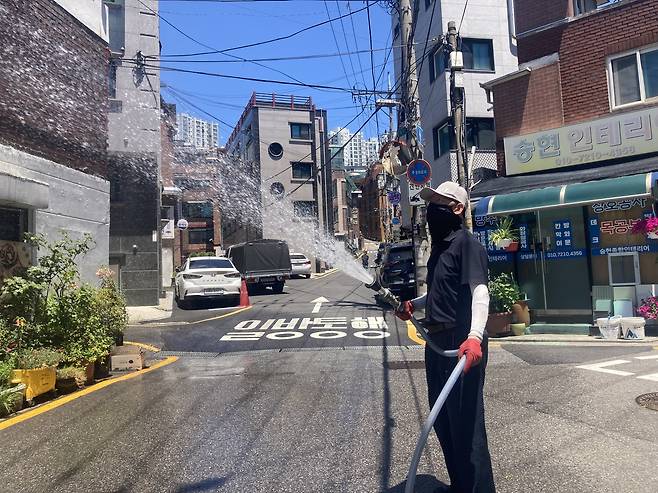살수 방역 직원이 관악구 한 건물에 물을 뿌리고 있는 모습. 손인규 기자