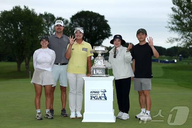 유해란이 29일(한국시간) KPMG 위민스 PGA 챔피언십에서 우승한 뒤 가족, 캐디 등과 함께 기념 촬영을 하고 있다. ⓒ AFP=뉴스1