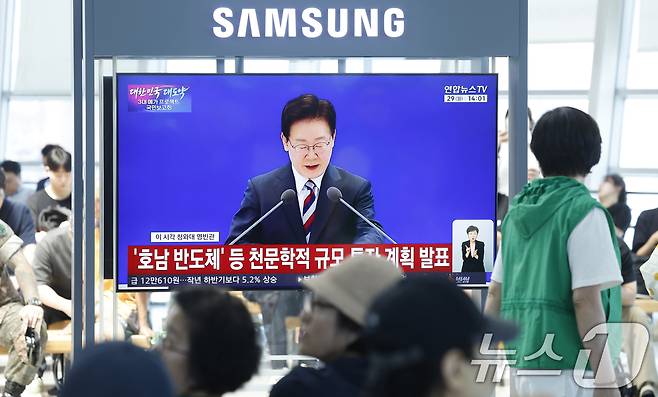 광주 시민들이 29일 광주 KTX송정역에서 청와대 영빈관에서 열린 '대한민국 대도약 3대 메가프로젝트 국민보고회'의 이재명 대통령의 투자 발표 생중계 뉴스를 지켜보고 있다. 2026.6.29 ⓒ 뉴스1 김태성 기자
