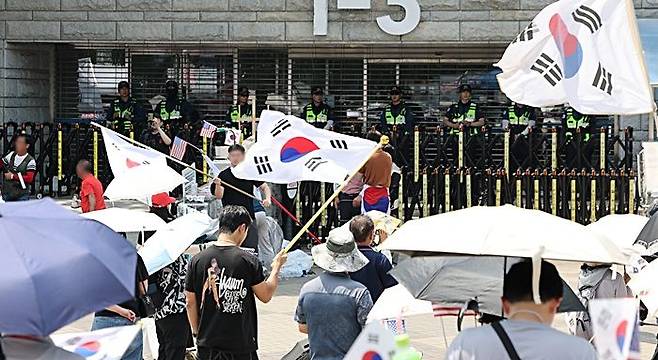 6·3 지방선거 당시 잠실 개표소로 사용된 서울 송파구 올림픽공원 핸드볼경기장 앞에서 28일 투표용지 부족 사태 규탄 봉쇄 시위 참가자들이 우산을 쓰고 구호를 외치고 있다. ⓒ연합뉴스