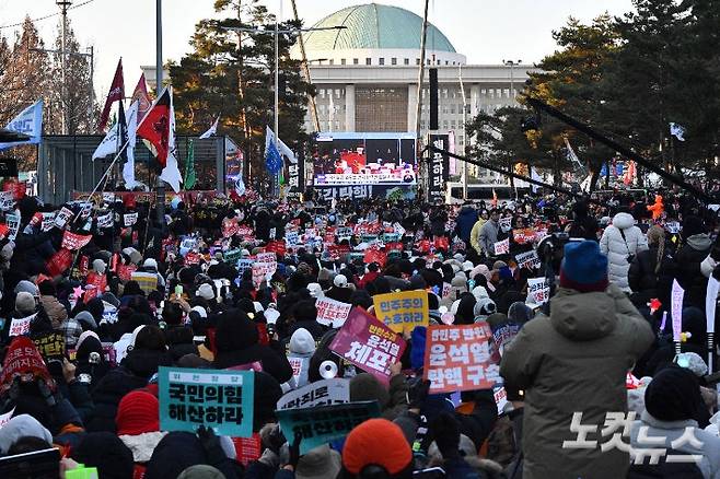 2024년 12월 14일 오후 서울 여의도 국회의사당 앞에서 시민들이 윤석열 대통령 탄핵소추안 재표결 상황을 생중계로 지켜보며 구호를 외치고 있다. 류영주 기자