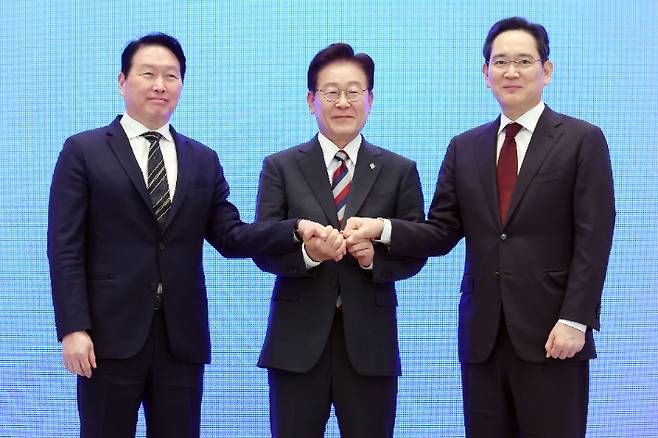 이재명 대통령과 이재용 삼성전자 회장, 최태원 SK그룹 회장이 29일 청와대에서 열린 3대 메가프로젝트 국민보고회에서 기업 투자계획 발표 후 손을 잡고 있다. 연합뉴스