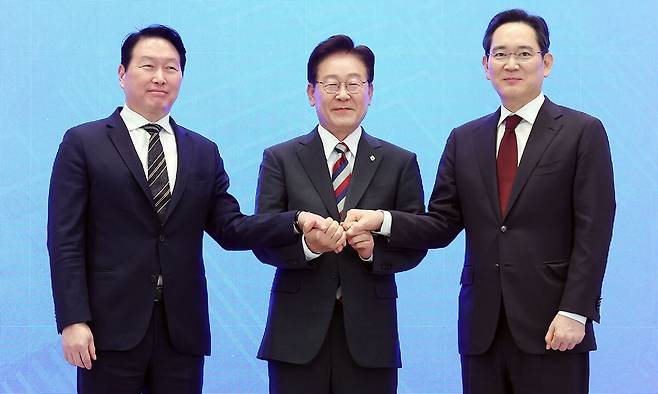 이재명 대통령과 이재용 삼성전자 회장, 최태원 SK그룹 회장이 29일 청와대에서 열린 3대 메가프로젝트 국민보고회에서 기업 투자계획 발표 후 손을 잡고 있다.&nbsp; &nbsp;연합뉴스