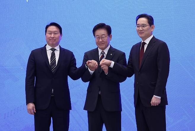 이재명 대통령과 이재용 삼성전자 회장, 최태원 에스케이(SK)그룹 회장이 29일 청와대에서 열린 ‘대한민국 대도약 3대 메가프로젝트 국민보고회’에서 손을 맞잡고 있다. 2026.06.29. 청와대사진기자단