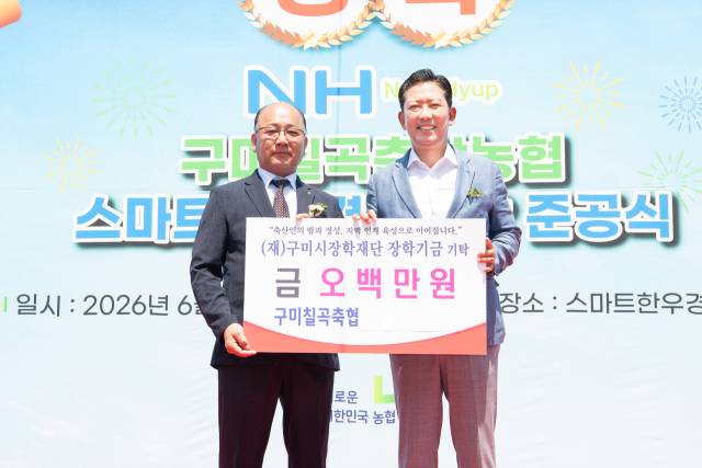 장영익(왼쪽) 구미칠곡축협 조합장이 스마트 가축경매시장 준공식에서 김장호 구미시장에게 장학기금을 전달한 뒤 기념촬영을 하고 있다. 구미시 제공
