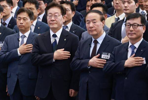 이재명 대통령이 30일 광주 김대중컨벤션센터에서 열린 서남권 첨단산업 발전비전 국민보고회에서 국민의례를 하고 있다. 왼쪽부터 곽노정 SK하이닉스 대표, 이재명 대통령, 전영현 삼성전자 부회장, 이진안 앰코테크놀로지코리아 대표. [출처=연합]