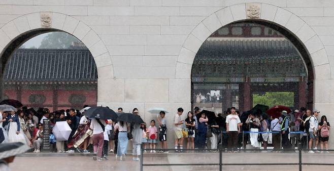 서울 전역에 소나기가 내린 지난 14일 서울 종로구 광화문광장에서 시민과 관광객들이 우산을 들고 비를 피하고 있다. (사진=뉴시스)