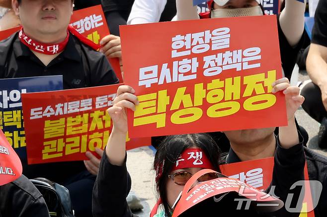 도수치료 관리급여 전환을 앞두고 28일 서울 종로구 경복궁 인근에서 열린 도수치료 생존권 수호 전국 물리치료사 총궐기대회에서 참가자들이 손피켓을 들고 '현실 무시 획일적 관리급여, 환자 중심 전면 재설계' 등을 촉구하고 있다.  2026.6.28 ⓒ 뉴스1 이광호 기자