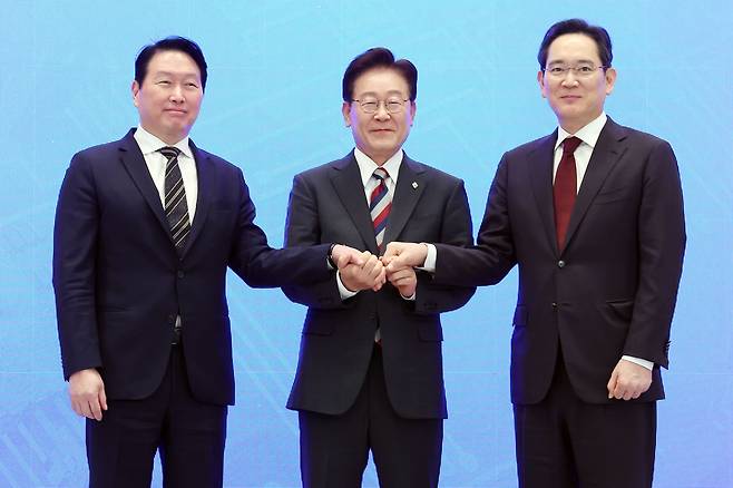이재명 대통령과 이재용 삼성전자 회장, 최태원 SK그룹 회장이 29일 청와대 영빈관에서 열린 대한민국 대도약 3대 메가프로젝트 국민보고회에서 손을 맞잡고 있다./뉴스1