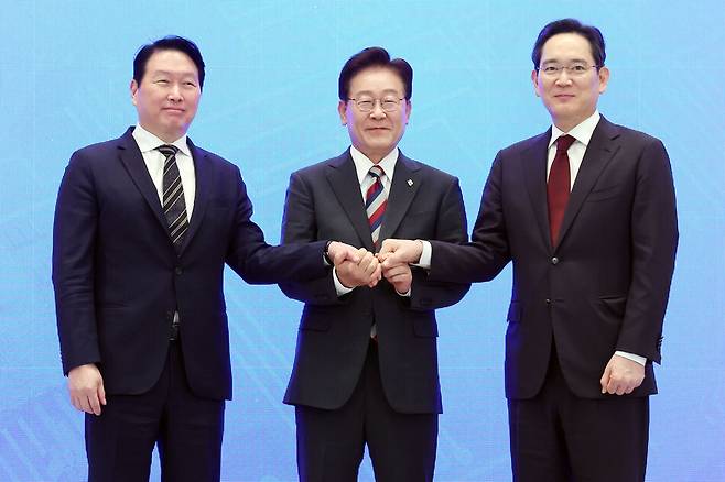 이재명 대통령과 이재용 삼성전자 회장, 최태원 SK그룹 회장이 29일 청와대에서 열린 3대 메가프로젝트 국민보고회에서 기업 투자계획 발표 후 손을 잡고 있다. 연합뉴스