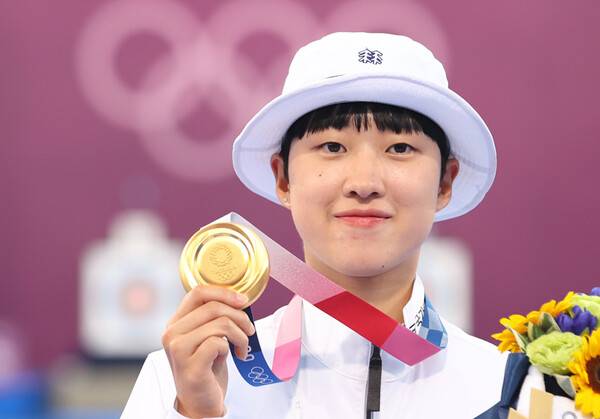 ▲ 양궁 3관왕을 차지한 안산이 2021년 7월30일 일본 유메노시마 공원 양궁장에서 열린 도쿄올림픽 양궁 여자 개인전 시상식을 마친 뒤 금메달을 들어 보이고 있다. ⓒ연합뉴스