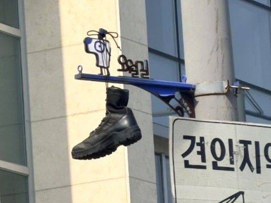 [광주=뉴시스] 30일 오후 2시께 광주 동구 대인동 구 시외버스터미널 인근 교차로 '5월길' 안내 표지판에 군화가 끈으로 묶여 매달려 있다. (사진=5·18기념재단 제공) 2026.06.30. photo@newsis.com *재판매 및 DB 금지
