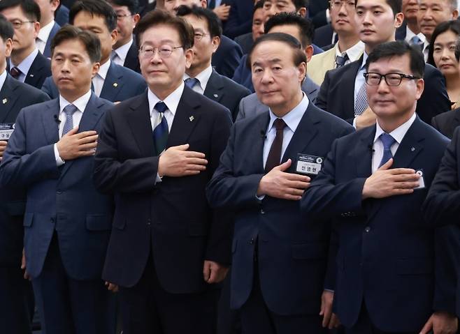 국민의례하는 이재명 대통령 - 이재명 대통령이 30일 광주 김대중컨벤션센터에서 열린 서남권 첨단산업 발전비전 국민보고회에서 국민의례를 하고 있다. 왼쪽부터 곽노정 SK하이닉스 대표, 이재명 대통령, 전영현 삼성전자 부회장, 이진안 앰코테크놀로지코리아 대표. 광주 연합뉴스