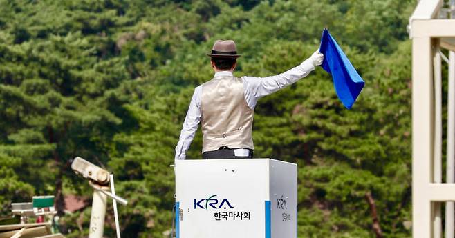 현장 직원이 트랙 위에서 청색 깃발을 흔들고 있다. (사진=한국마사회)