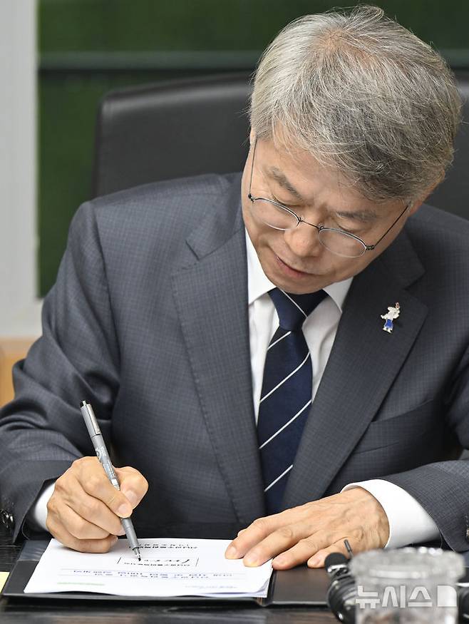 [순천=뉴시스] 박기웅 기자 = 민형배 초대 전남광주통합특별시장이 취임 첫날인 1일 오전 전남광주 순천시 동부청사로 출근해 업무보고를 받고 취임 제1호 결재로 '민생 지원 및 통합 100일 실행계획'에 서명을 하고 있다. 2026.07.01. pboxer@newsis.com