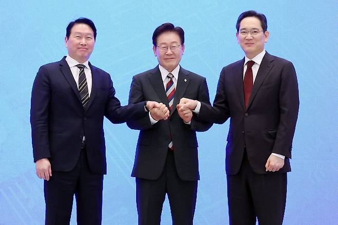 이재명 대통령(가운데)과 이재용 삼성전자 회장(오른쪽), 최태원 SK 회장이 6월 29일 청와대 영빈관에서 열린 ‘대한민국 대도약 3대 메가프로젝트 국민보고회’에서 손을 맞잡고 있다.&nbsp;뉴시스