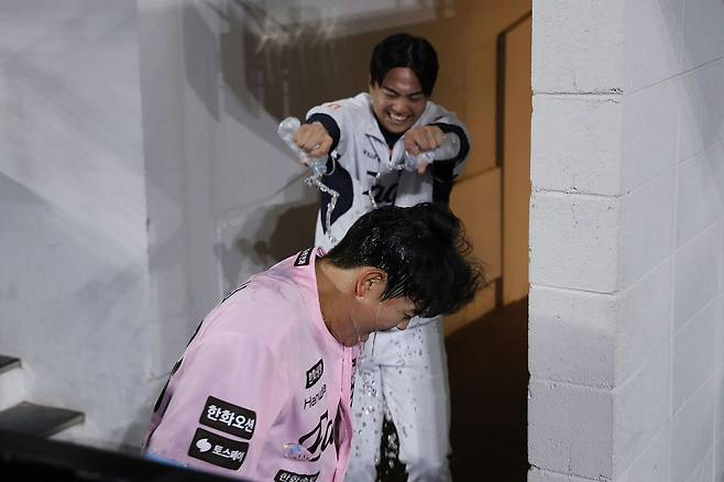 지난 5월 29일 데뷔 후 처음으로 두 자릿수 홈런을 친 동료 허인서에게 물을 뿌리며 즐겁게 축하하는 왕옌청. 사진 한화 이글스