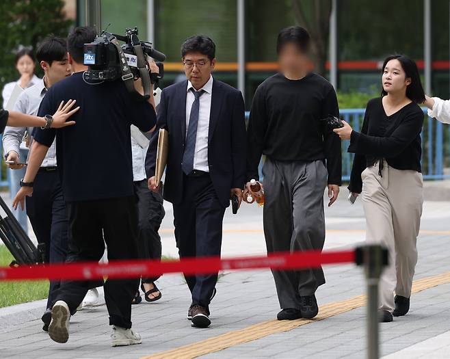 잠실 개표소 봉쇄 시위 첫날 경찰관을 폭행한 혐의를 받는 20대 남성이 2일 서울 송파구 동부지법에서 열린 영장실질심사에 출석하기 위해 법정으로 향하고 있다. [연합]
