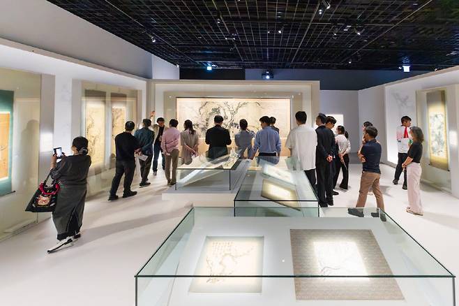 대구간송미술관 기획전 《추사의 그림 수업》 전시장을 찾은 관람객들이 우봉 조희룡의 대작 <홍백매도> 앞에 멈추어 서서 그림을 감상하고 있다. 거칠게 뻗어 나간 고목과 난만한 매화 꽃잎들이 뿜어내는 호방한 필치가 시선을 붙잡는다.