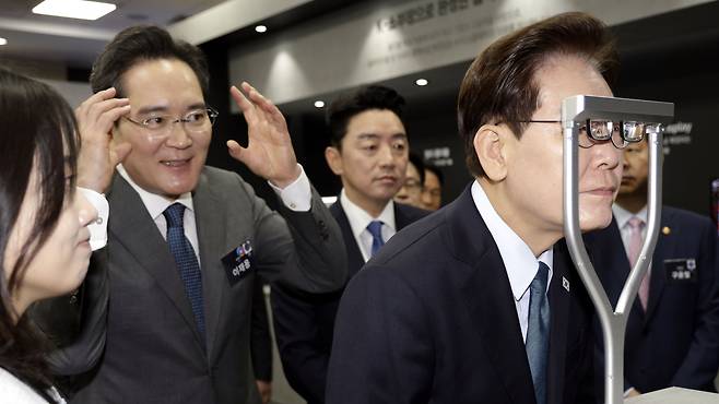 이재명 대통령이 2일 충남 아산에서 열린 ‘충청권 첨단산업 발전비전 국민보고회’에서 이재용 삼성전자 회장이 지켜보는 가운데 증강현실(AR) 글라스 시제품을 체험하고 있다. /뉴스1