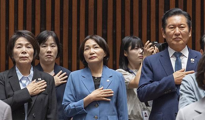 민주당 정청래(오른쪽) 전 대표가 29일 국회에서 열린 의원총회에서 국기에 경례하고 있다. 연합뉴스