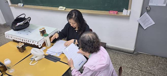 선생님 앞에서 영어 문장을 읽고 있는 송영자씨의 모습