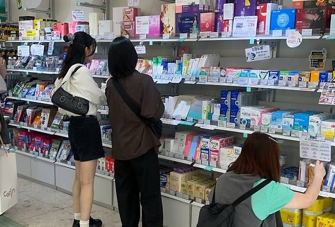 외국인 관광객들이 약국에서 화장품을 사는 모습. / 사진=한경DB