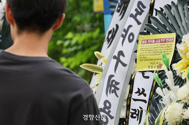 광주일고를 향해 5·18민주화운동 폄하 의미 구호를 외쳐 논란이 된 서울 강동구 배재고에 2일 경조 화환이 놓여 있는 가운데 불법 적치물 자율정비 안내문이 부착돼 있다. 한수빈 기자
