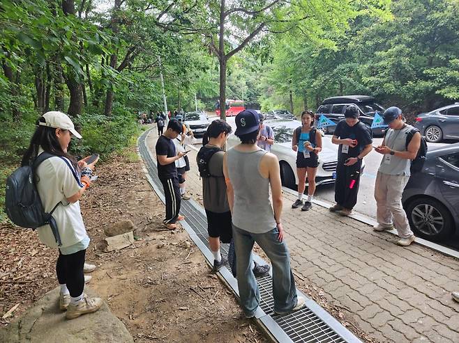 5일 서울 관악구가 마련한 등산형 소개팅 프로그램 '등산해듀오' 참가자들이 산행을 마친 뒤 휴대폰으로 호감도 1순위 상대를 선택하고 있다. 오세운 기자
