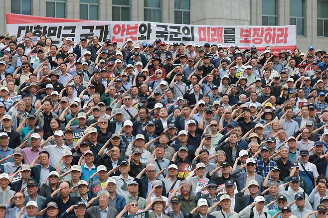8일 국회 본청 앞 계단에서 육·해·공군사관학교 총동창회, 육사 사관생도 학부모 모임과 함께 연 육·해·공군사관학교 통폐합 및 육군사관학교 지방 이전 반대 총궐기 대회에서 참석자들이 국기에 경례하고 있다.  [연합]