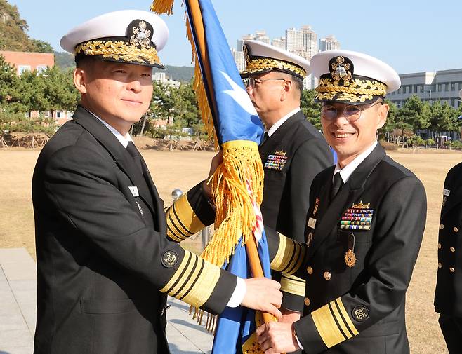 지난해 11월 18일 강동길 해군참모총장(왼쪽)이 신임 해군작전사령관 김경률 중장에게 부대기를 전달하고 있다. 지난해 9월 해군참모총장에 오른 강동길 대장은 올해 2월 내란 관련 행위로 직무가 정지됐고, 징계가 결정된 뒤 스스로 사퇴했다. (출처:연합)