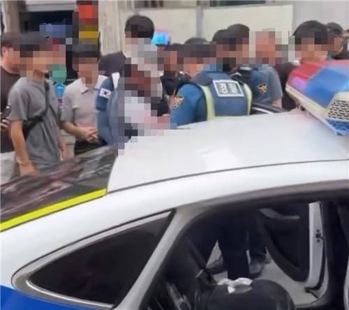 거제경찰서는 미용실에서 종업원과 손님을 살해하려 한 혐의(살인미수)로 80대 ㄱ 씨를 9일 송치했다. 사진은 경찰이 ㄱ 씨를 연행하는 모습. /연합뉴스
