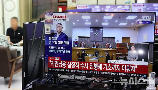 [서울=뉴시스] 김명년 기자 = 9일 오후 서울 용산구 용산전자상가 TV 매장에서 지난 12·3 비상계엄 이후 고위공직자범죄수사처의 체포영장 집행을 방해한 혐의 등으로 기소된 윤석열 전 대통령에 대한 대법원의 징역 7년 확정 판결 뉴스가 나오고 있다. 2026.07.09. kmn@newsis.com