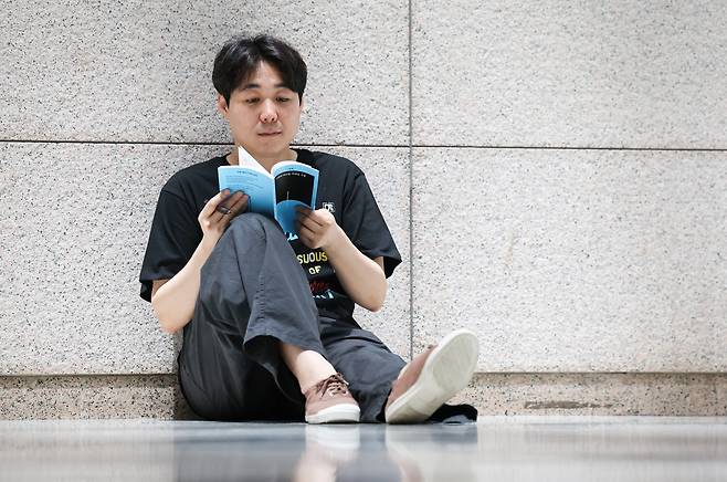고명재 시인이 신작 시집 '어깨에 머리를 기대던 시절'을 펼쳐 보고 있다. /박성원 기자