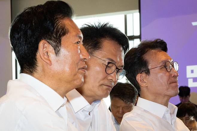 더불어민주당 당 대표 선거에 나서는 당권 주자들이 3일 서울 용산구에서 열린 더불어민주당 국회의원 워크숍에 참석해 한병도 대표 직무대행 겸 원내대표의 인사말을 듣고 있다. 왼쪽부터 정청래 전 대표와 송영길 전 대표, 김민석 전 국무총리. 뉴스1