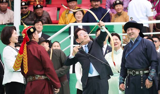 몽골을 국빈 방문 중인 이재명 대통령이 11일(현지시간) 울란바타르 나담축제장에서 전통활쏘기를 체험하고 있다. 오른쪽은 오흐나 후렐수흐 몽골 대통령. 뉴스1