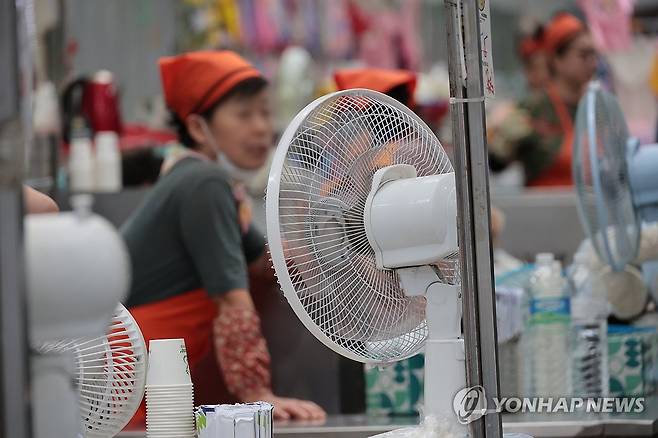 선풍기로 잊어보는 더위 (대구=연합뉴스) 황수빈 기자 = 폭염특보가 내려진 12일 대구 중구 서문시장에서 한 상인이 선풍기로 더위를 달래고 있다. 2026.7.12 hsb@yna.co.kr