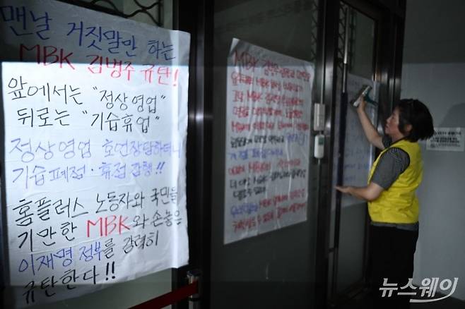민주노총 서비스연맹 마트산업노동조합이 14일 오후 서울 강서구 홈플러스 본사 앞에서 열린 MBK의 일방적 면담 취소 규탄 및 노동조합 입장발표 기자회견을 마친 뒤 출입구에 항의 대자보를 부착하고 있다. 사진=강민석 기자