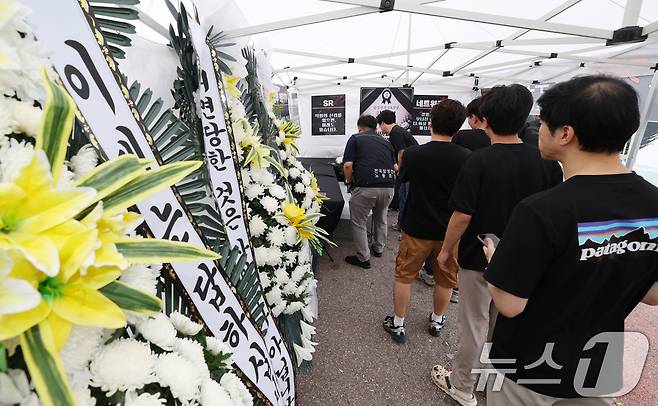 14일 경기 수원시 영통구 삼성전자 수원사업장 중앙문에서 열린 'DX부문 사기진작 및 보상마련 촉구 집회'에서 조합원들이 '2026 DX부문 사망선고 위로를 위한 조문 행사'에 참여하고 있다. 2026.7.14 ⓒ 뉴스1 김영운 기자