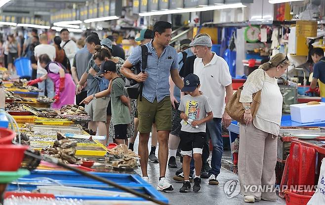 부산 중구 자갈치시장을 찾은 외국인 관광객들이 시장을 둘러보며 수산물을 고르고 있다. [연합뉴스 자료사진. 재판매 및 DB 금지]