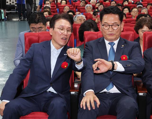 더불어민주당 8·17 전당대회 당대표 경선에 출마한 김민석(왼쪽) 전 국무총리와 송영길(오른쪽) 전 대표가 지난 7월 13일 경기도 성남시 분당구 새마을운동중앙연수원에서 열린 민주당 전국 시ㆍ도 노인위원장 워크숍에서 시계를 보며 대화하고 있다. [연합뉴스]