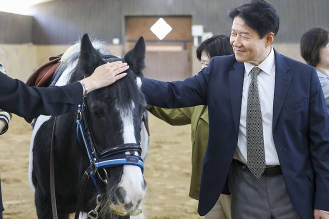 말을 쓰다듬고 있는 한국마사회 우희종 회장