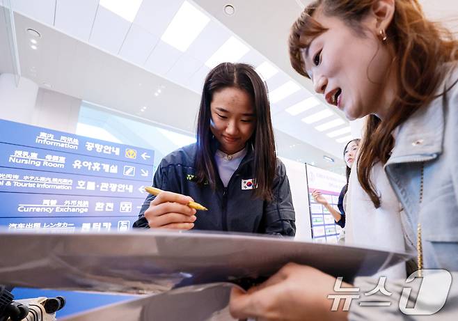 2026년 세계여자단체배드민턴선수권대회(우버컵) 대표팀 안세영이 5일 인천공항 제2여객터미널을 통해 귀국해 팬에게 싸인을 해주고 있다. 2026.5.5 ⓒ 뉴스1 이호윤 기자
