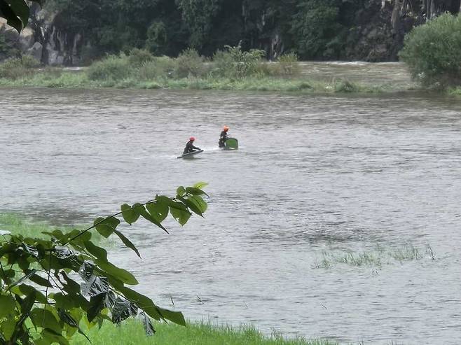 A rescue team searches for a fisherman who went missing after being swept away by swollen waters in the Jucheon River in Yeongwol County, Gangwon, on July 18. GANGWON STATE FIRE HEADQUARTERS