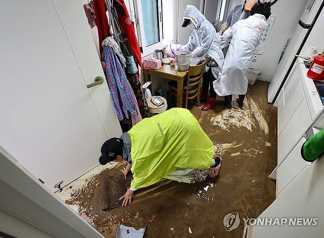 폭우에 침수된 산불이재민 임시주택 (안동=연합뉴스) 윤관식 기자 = 19일 경북 안동시 일직면 귀미1리에 설치된 산불 이재민 임시주택에서 자원봉사자가 폭우로 밀려 들어온 토사를 닦아내고 있다. 2026.7.19 psik@yna.co.kr