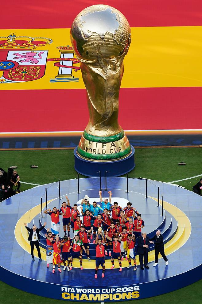Spain's Rodri (16) lifts the trophy as Spain celebrates along side President Donald J. Trump and FIFA President Gianni Infantino, right, after winning the World Cup final soccer match between Spain and Argentina in East Rutherford, N.J., near New York, Sunday, July 19, 2026.(AP Photo/Seth Wenig)<저작권자(c) 연합뉴스, 무단 전재-재배포, AI 학습 및 활용 금지>