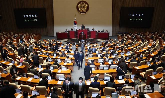 [서울=뉴시스] 고범준 기자 = 윤상현 국민의힘 의원이 20일 서울 여의도 국회에서 열린 제437회 국회(임시회) 제1차 본회의에서 윤석열·김건희에 의한 내란·외환 및 국정농단 행위의 진상규명을 위한 특별검사 임명 등에 관한 법률 일부개정법률안(대안)에 대해 무제한토론(필리버스터)을 하고 있는 가운데 민주당 의원들이 이동하고 있다. 2026.07.20. bjko@newsis.com